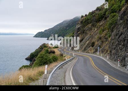 Belle route avec ciel nuageux le long du lac Wakatipu, Queenstown, Nouvelle-Zélande. Banque D'Images