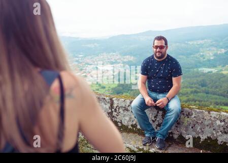Deux amis ayant une conversation devant un beau paysage avec des montagnes et des forêts Banque D'Images