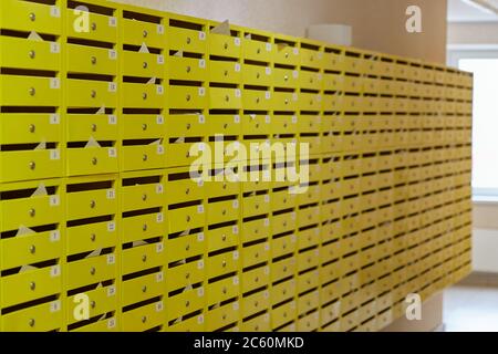 Boîtes aux lettres jaunes et rangées de cadenas à l'entrée. Banque D'Images