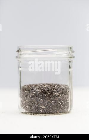 graines de chia bio dans un pot en verre sur fond gris. Concept de régime alimentaire sain. Super food. Espace de copie sélectif Banque D'Images