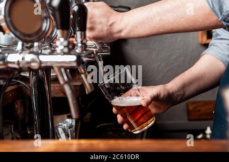 Bière artisanale à partir d'un fût. Le barman verse de la bière dans le verre du robinet Banque D'Images