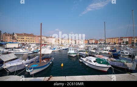 Bateaux à moteur et bateaux sur l'eau dans le port de Rovinj, Croatie. Yachts débarquant, maisons anciennes de la vieille ville sur le fond. Banque D'Images