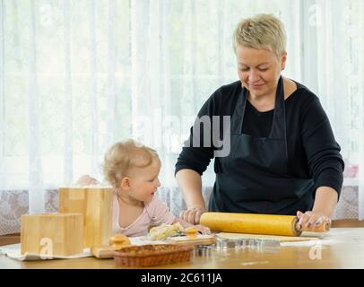 Grand-mère heureux et bébé mignon amusant en cuisinant, pâtisseries maison Banque D'Images