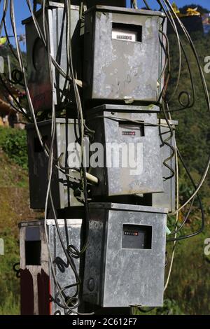 Boîtiers de compteurs électriques sur un poteau dans les Philippines rurales. Compteurs d'électricité. Banque D'Images