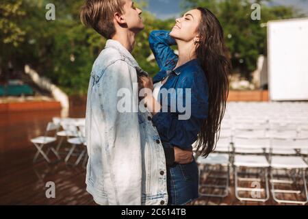 Portrait d'un jeune couple souriant debout et enfermé sous la pluie le jour dans le parc Banque D'Images