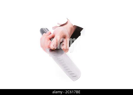 main masculine avec un chef avec un couteau à travers un trou dans le papier sur un fond blanc isoler. gros plan, espace de copie. Banque D'Images