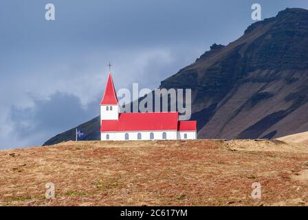 Église de Reyniscyrka avec toit rouge sur une colline avec un fond dramatique Vik, Islande Banque D'Images