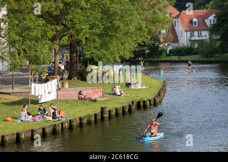 Vue sur la vieille île de la ville hanséatique de Luebeck avec la rivière Trave avec des personnes assises sur la rive Banque D'Images