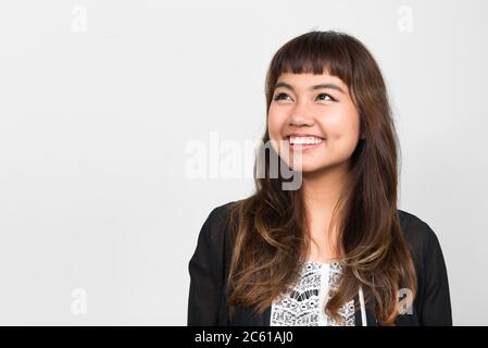 Portrait of happy young beautiful Asian woman thinking Banque D'Images