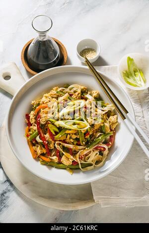 Thaïlande Street food - Pad Thai avec tofu dans une assiette sur une table, dans un restaurant ou un café Banque D'Images