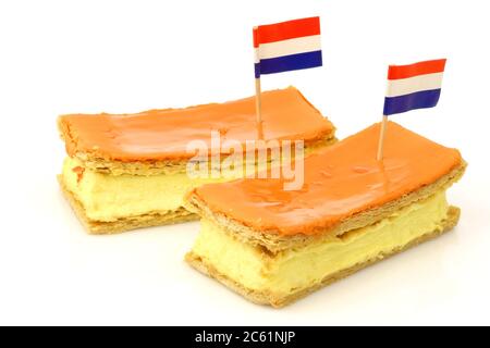 La traditionnelle pâtisserie hollandaise appelée « tompouce » avec un drapeau hollandais spécialement produit pour le Kings Day le 27 avril en Hollande sur fond blanc Banque D'Images