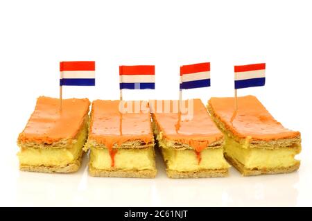 La traditionnelle pâtisserie hollandaise appelée « tompouce » avec un drapeau hollandais spécialement produit pour le Kings Day le 27 avril en Hollande sur fond blanc Banque D'Images