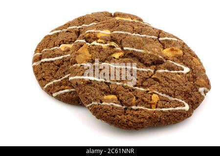 Biscuits croquants aux pépites de chocolat avec noix décorées de chocolat blanc sur fond blanc Banque D'Images