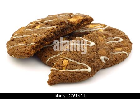 Biscuits croquants aux pépites de chocolat avec noix décorées de chocolat blanc sur fond blanc Banque D'Images