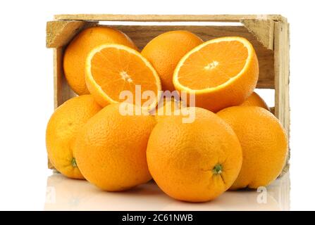 oranges fraîches dans une boîte en bois sur fond blanc Banque D'Images