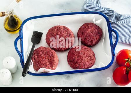 côtelettes végétaliennes crues pour hamburgers sans viande sur une plaque de cuisson sur une table Banque D'Images