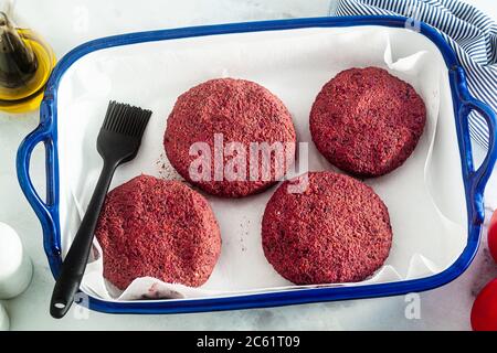 côtelettes végétaliennes crues pour hamburgers sans viande sur une plaque de cuisson sur une table Banque D'Images