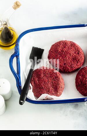 côtelettes végétaliennes crues pour hamburgers sans viande sur une plaque de cuisson sur une table Banque D'Images