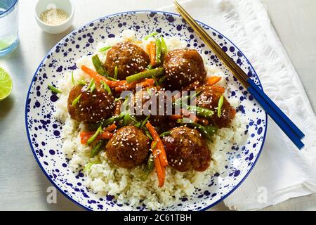 Boulettes de viande asiatiques végétaliennes en sauce aigre-douce avec riz et légumes rasées. Déjeuner équilibré ou dîner sain. Cuisine de rue Banque D'Images