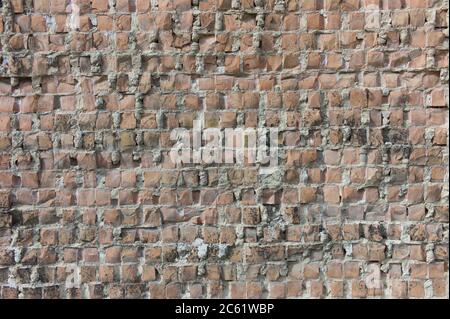 Image d'un vieux mur de pierre en brique grungy fait de pierres carrées cuites au four Banque D'Images