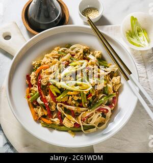 Thaïlande Street food - Pad Thai avec tofu dans une assiette sur une table, dans un restaurant ou un café Banque D'Images