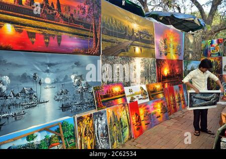 CAMBODGE, SIEM REAP - DEC 28, 2011: Magasin-garçon non identifié montré dans le marché local de peintures. Les peintures indigènes sont un souvenir le plus populaire à Ang Banque D'Images