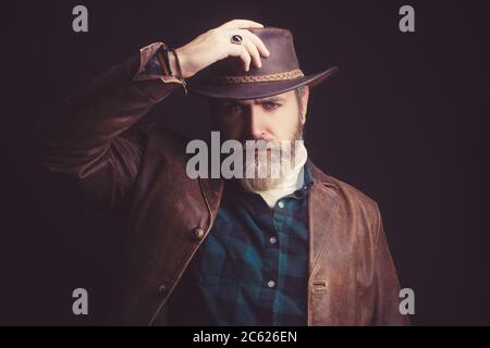 Le regard dur d'un homme du Far West. Portrait brutal d'un cow-boy dans un chapeau. Banque D'Images