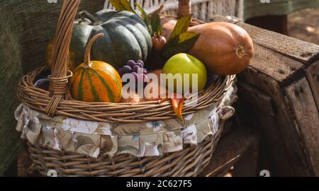 Magnifique panier avec récolte rurale d'automne - citrouilles, pommes et raisins. Banque D'Images