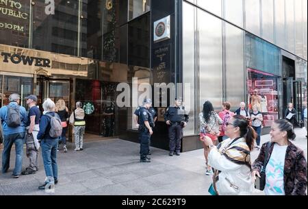 Trance à la Trump Tower à Manhattan, montrant les agents de sécurité de NYPD près de l'entrée près d'un trottoir très fréquenté. Banque D'Images