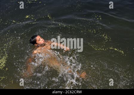 Srinagar, Inde. 06e juillet 2020. Un enfant naine dans le lac Dal pendant une chaude journée d'été à Srinagar. Crédit : SOPA Images Limited/Alamy Live News Banque D'Images