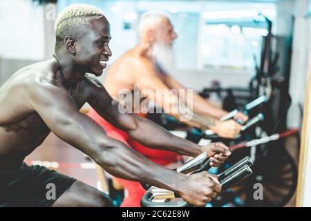 Des gens de différentes générations et ethnities faisant des séances d'entraînement sur cardio-cycette dans le club de gym - Fitness, spinning, mode de vie sain et s Banque D'Images