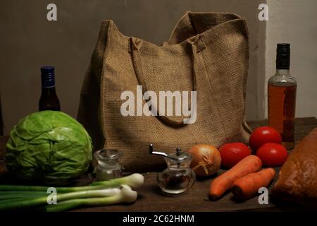 sac écologique en toile de jute naturelle avec supports de nourriture et de légumes sur une table en bois. Concept ECO. Banque D'Images