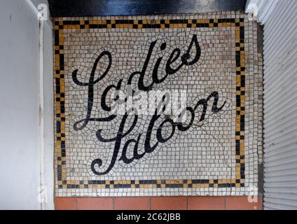 VIEUX PLANCHER MOSAÏQUE ENTRÉE SINAGE POUR UNE LONGUE FEMME FERMÉE SALOON DANS LE QUARTIER DE NOTTING HILL À LONDRES. Banque D'Images