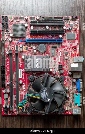 Ukraine - 25 avril 2020 : carte mère avec processeur sur fond marron. Composants matériels. Vue à l'intérieur, arrière-plan Banque D'Images