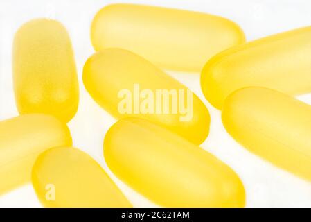 Macro-shot de capsules de gélatine jaune, isolé sur fond blanc. Banque D'Images