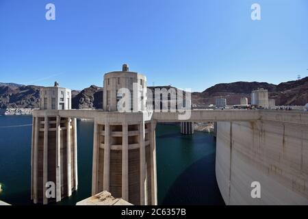 Les tours d'admission du barrage Hoover vus du Nevada par une journée claire et le ciel bleu. Des piétons sont visibles en marchant le long du haut du barrage. Banque D'Images