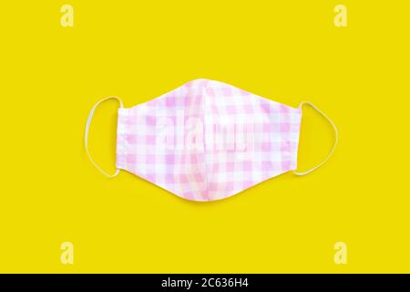 Masque en tissu coloré fait main sur fond jaune. Copier l'espace Banque D'Images