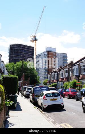 Un horizon de banlieue changeant, une grue Tower en action pour construire de nouveaux appartements Banque D'Images