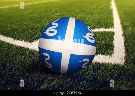 Drapeau Martinique sur le ballon en position de coup de pied au coin, fond du terrain de football. Thème national du football sur gazon. Banque D'Images
