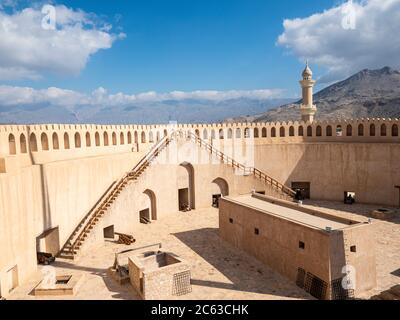 Le fort de Nizwa, la mosquée du Sultan Qaboos au loin, Nizwa, Sultanat d'Oman. Banque D'Images