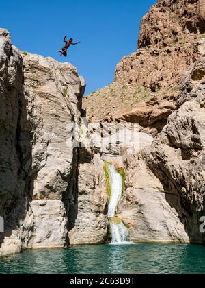 Un jeune homme bondissant dans des piscines naturelles à Wadi Bani Khalid, Sultanat d'Oman. Banque D'Images