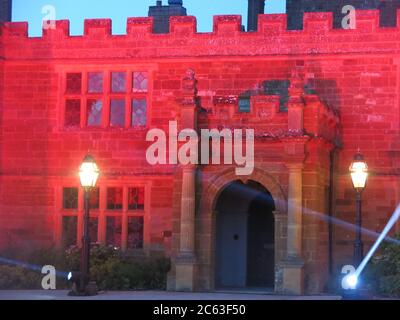 L'entrée et la façade de l'abbaye de Delaparc illuminées la nuit sous lumière rouge et avec des spots pour l'initiative # Light IT in Red ; 6 juillet 2020 Banque D'Images