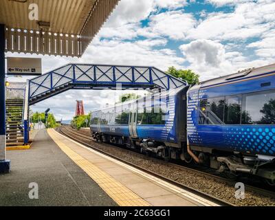 Un train Scotrail à North Queensferry Station avec le Forth Bridge en arrière-plan. Banque D'Images