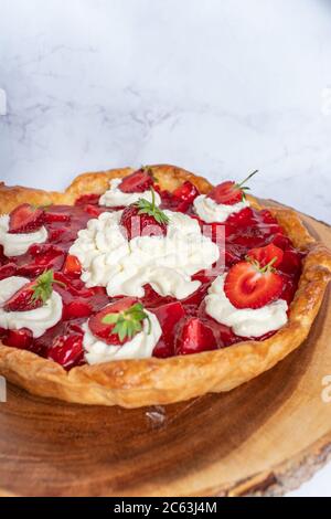 Tarte aux fraises maison avec crème fouettée sur fond blanc Banque D'Images