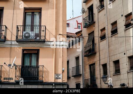 Détails de bas angle de l'extérieur des maisons résidentielles anciennes en pierre avec des murs de merde et des balcons situés dans le vieux quartier de Madrid Banque D'Images