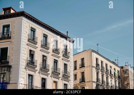 Angle bas des maisons avec de petits balcons sur fond de ciel bleu sans nuages Banque D'Images