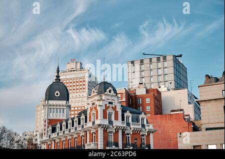 Depuis le dessous des maisons historiques anciennes et des bâtiments modernes sur fond de ciel bleu à Madrid Banque D'Images