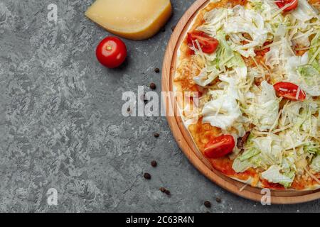 Délicieuse pizza Caesar avec sauce blanche, poulet, parmesan, œuf, tomates cerises et laitue fraîche sur fond de bois Banque D'Images