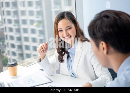 Femme d'affaires asiatique intelligente avec un client au bureau de la ville Banque D'Images