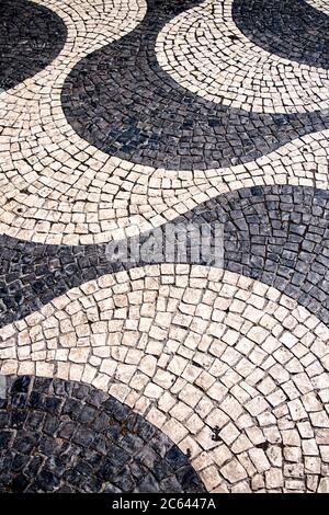 Les pavés portugais noirs et blancs appelés calcada forment un modèle de vague à Lisbonne, au Portugal. Banque D'Images